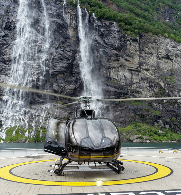 Helicopter on helipad on board Scenic Yacht with waterfall behind