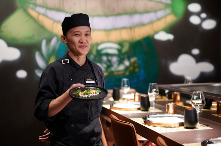 Chef displaying food server at Kokos Night Market on board Scenic Eclipse